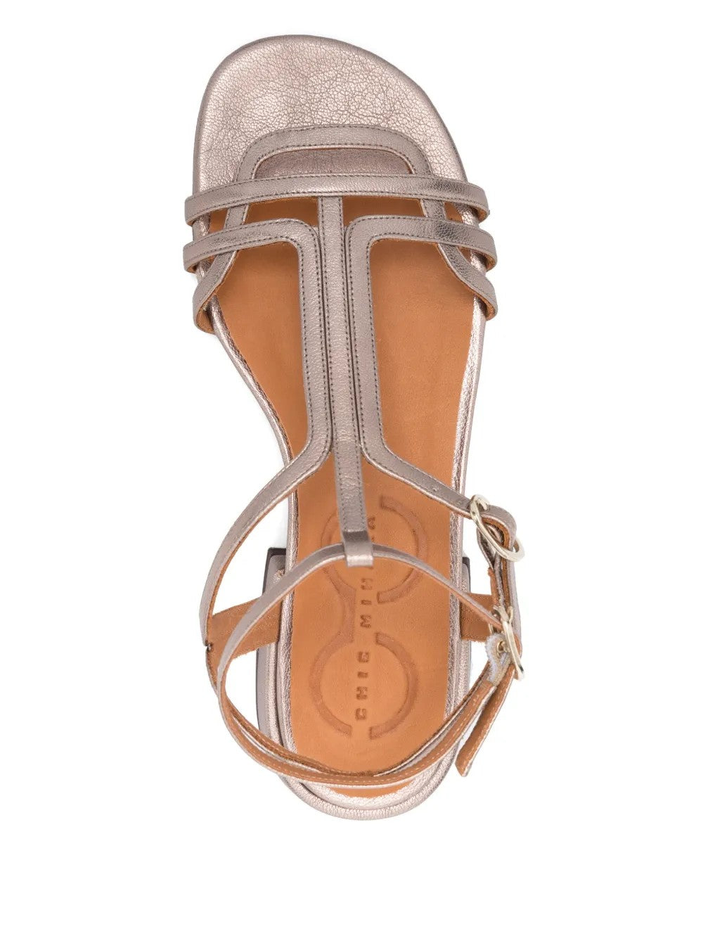 Sandalia plana Chie Mihara TYAL en piel plateada con cierre doble al tobillo y hebilla lateral. Con puntera abierta y tacón de 3 cm, es el calzado perfecto para un look cómodo y elegante. Fabricada en España, ideal para cualquier ocasión.