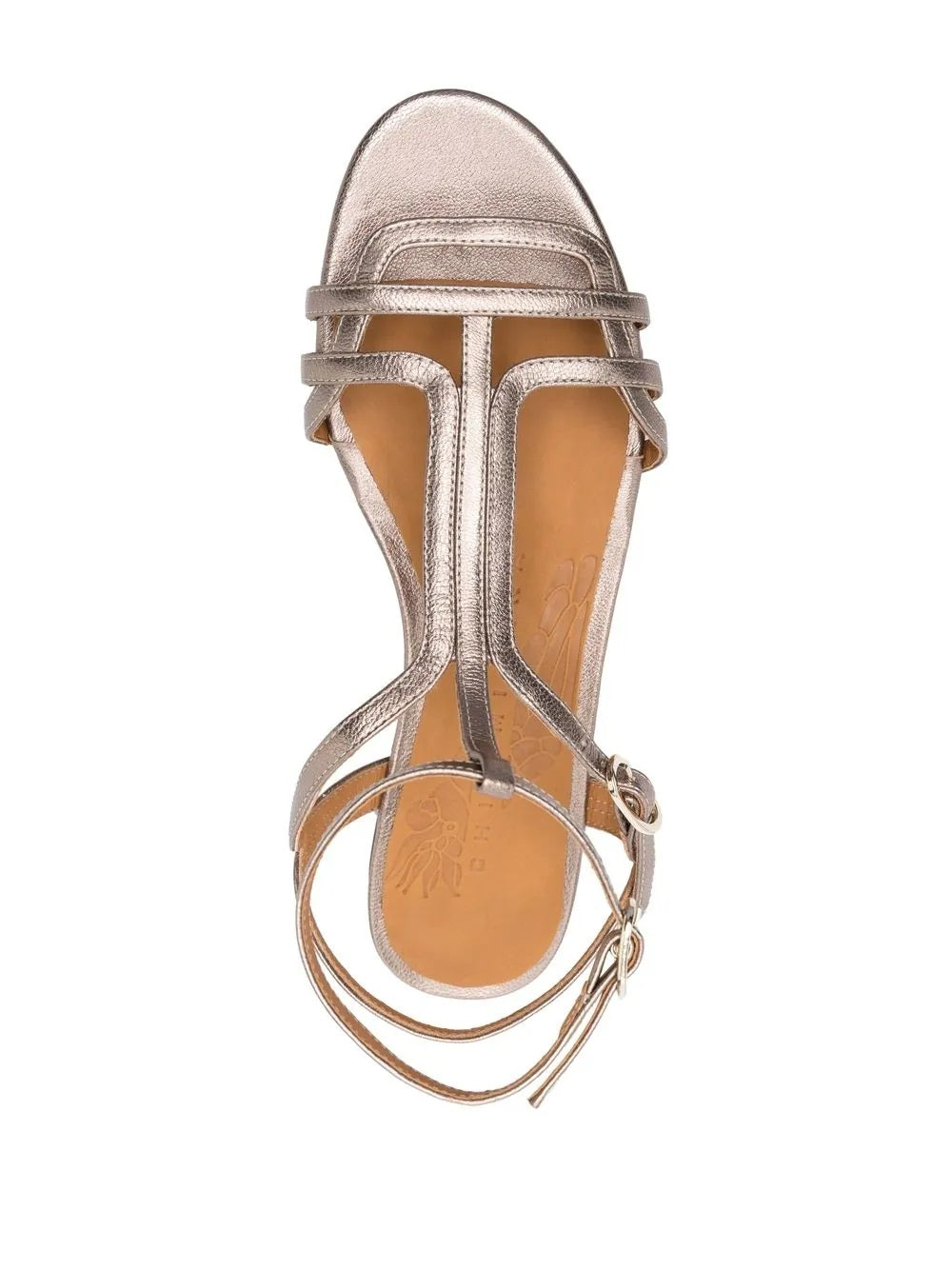 Sandalia plana Chie Mihara YAEL en piel plateada con cierre doble al tobillo, hebilla lateral y puntera abierta. Suela plana de cuero y goma, diseño cómodo y elegante.