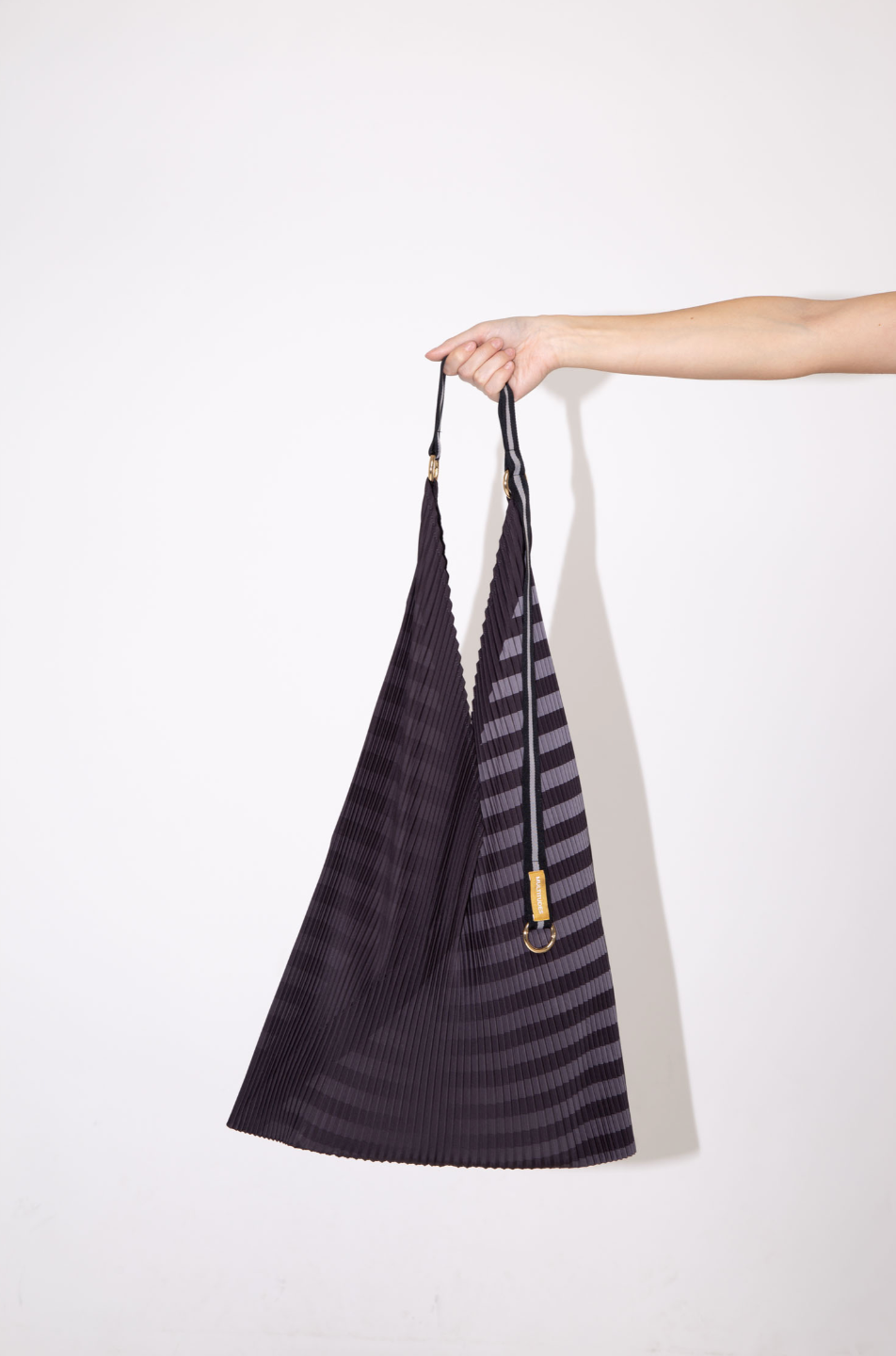 Bolso tote plisado modelo Claudia en negro y gris de Multitudes, confeccionado en poliéster reciclado con asas de satén, diseño versátil y elegante, fabricado en Italia.