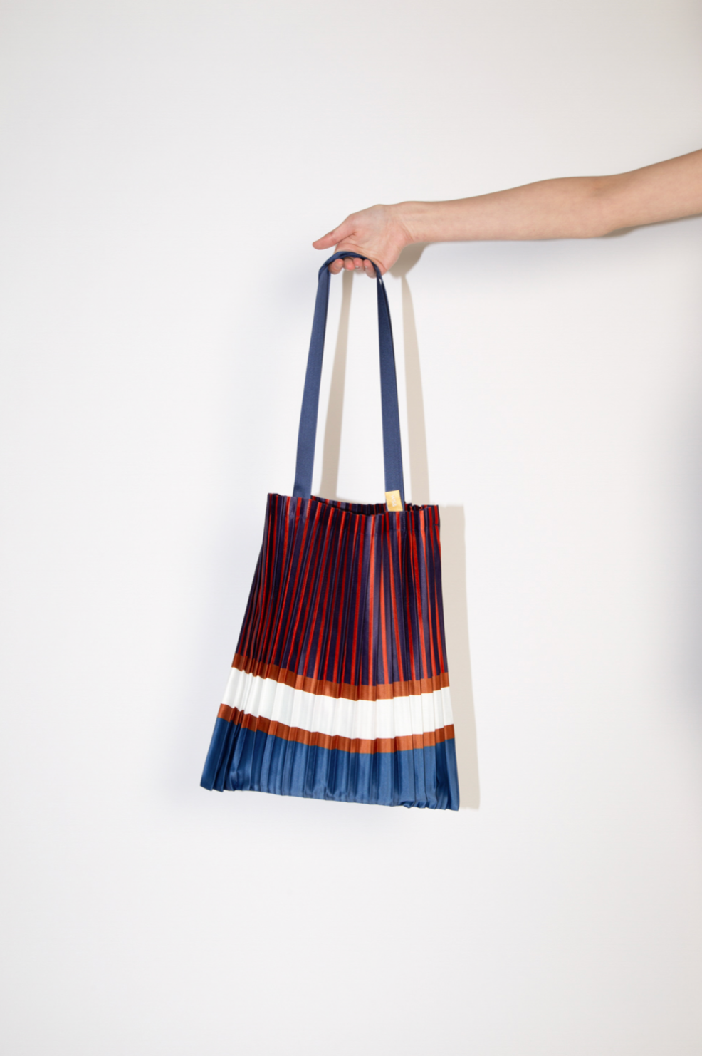 Bolso Tote Chiavari plisado en azul, burdeos y blanco de satén sintético reciclado. Diseño italiano sostenible de la marca Multitudes.