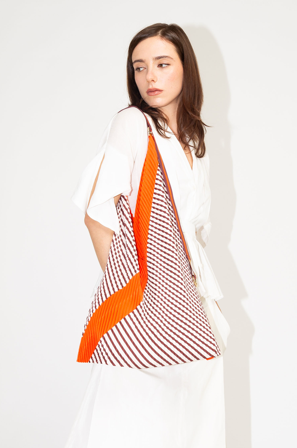 Bolso tote plisado Francesca Red de Multitudes en tonos burdeos y naranja, confeccionado en poliéster reciclado con acabado satinado efecto seda, con asas de satén resistentes y anilla dorada para accesorios. Ideal para uso diario con estilo y sostenibilidad.