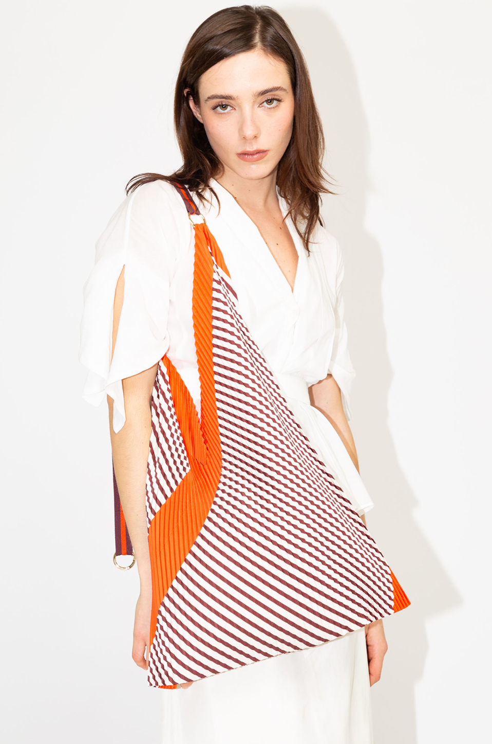 Bolso tote plisado Francesca Red de Multitudes en tonos burdeos y naranja, confeccionado en poliéster reciclado con acabado satinado efecto seda, con asas de satén resistentes y anilla dorada para accesorios. Ideal para uso diario con estilo y sostenibilidad.