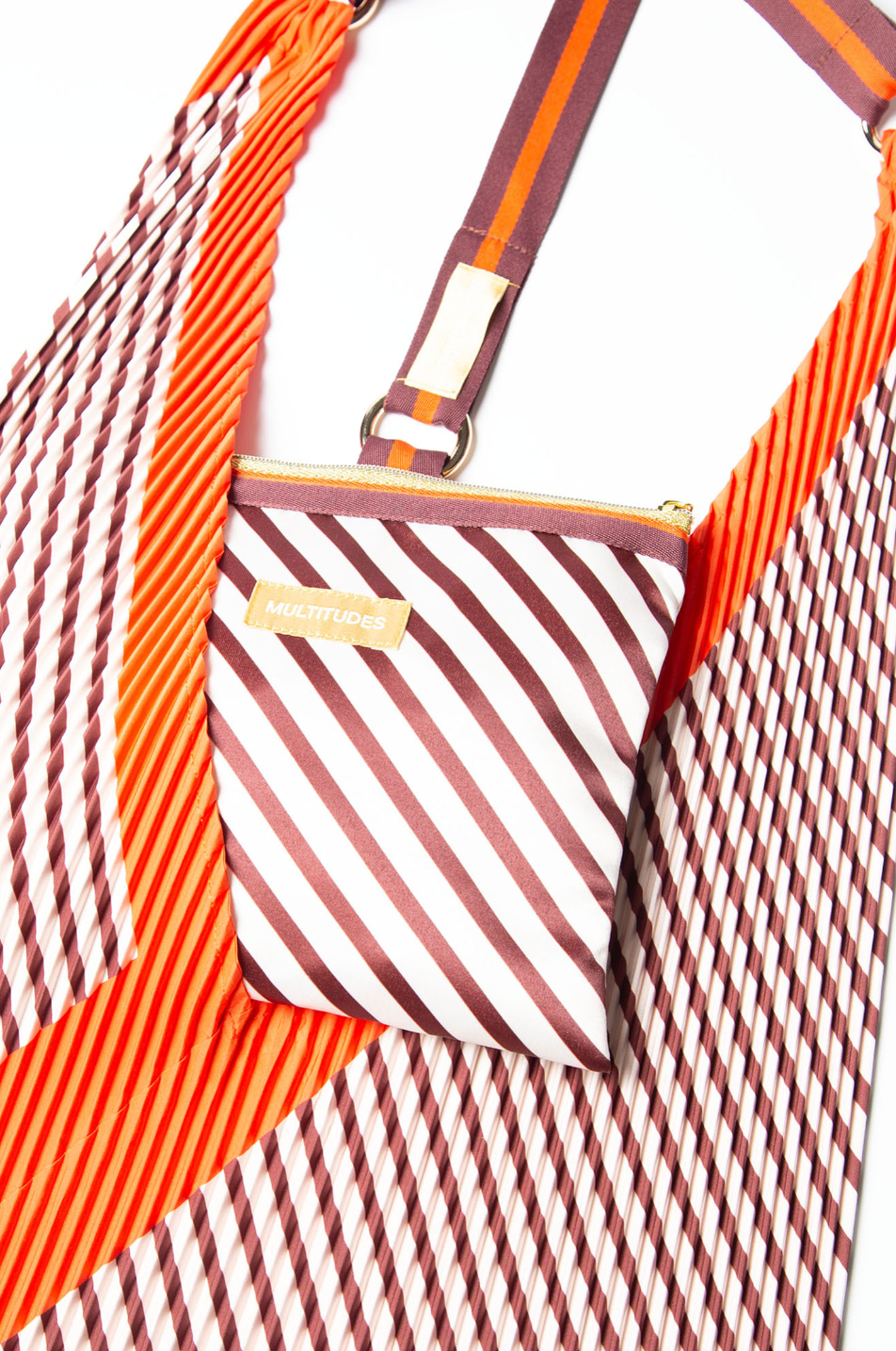 Pochette Francesca Red de Multitudes en burdeos y naranja, hecha de tejido reciclado efecto seda, con cremallera dorada y lazo superior para enganchar al bolso.