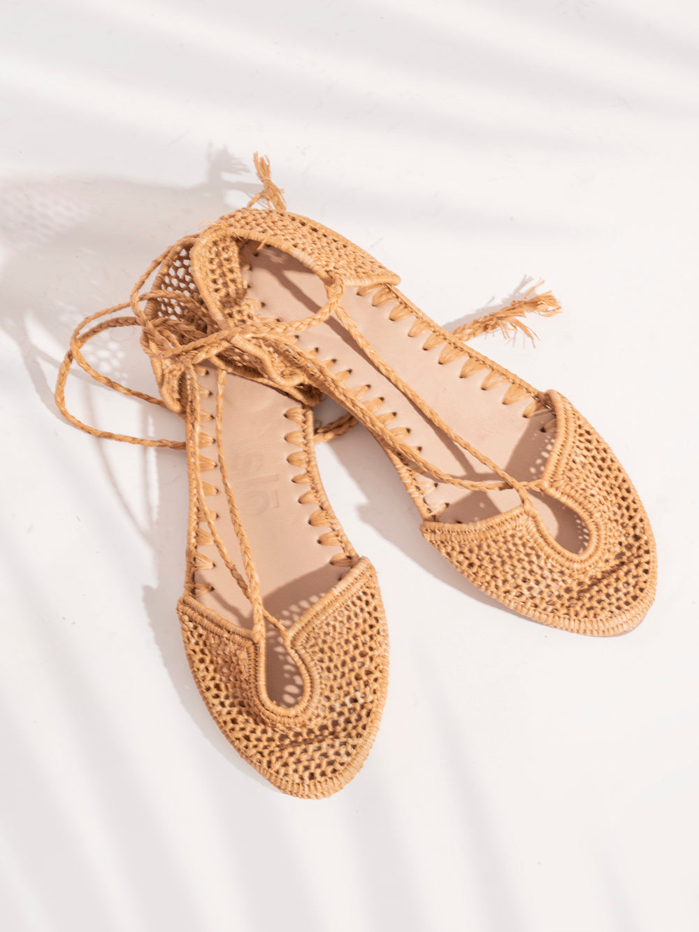Sustainable raffia flats in natural sand shade with roman straps and leather sole