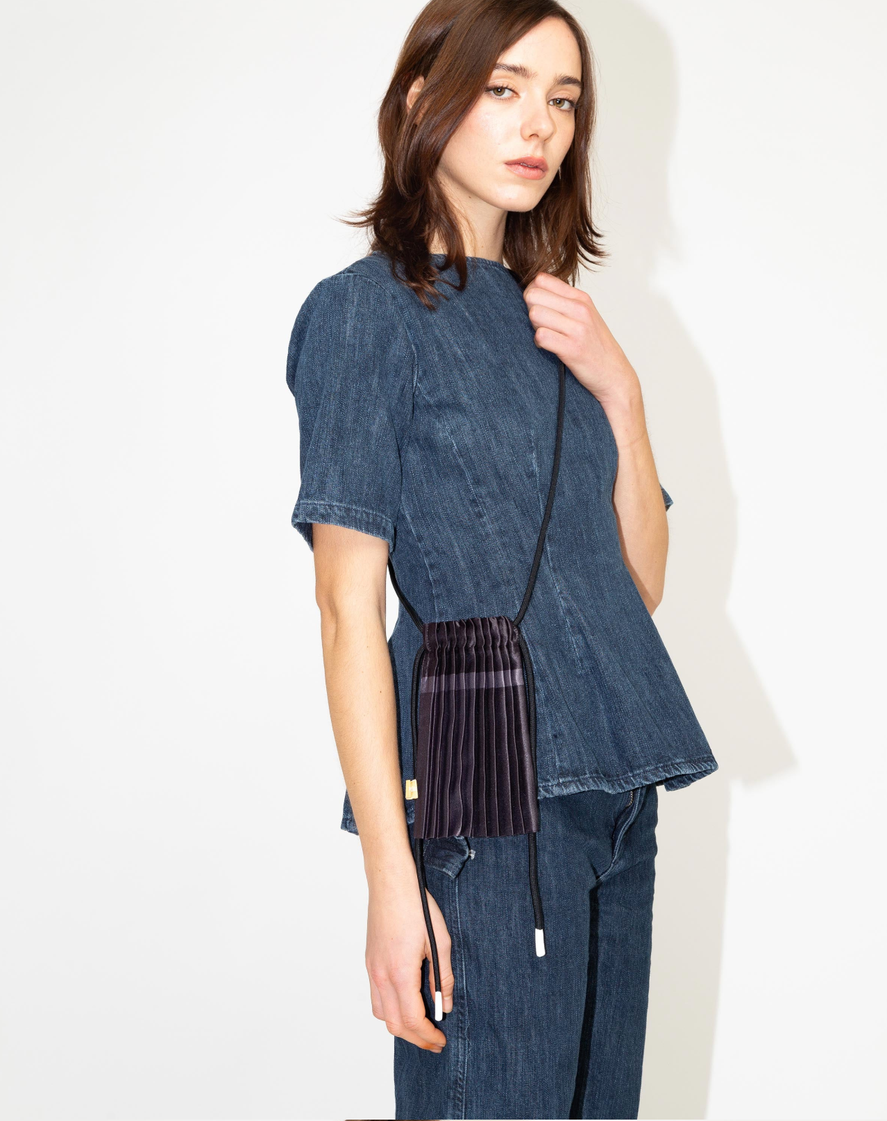 Multitudes pleated mini bag black worn on the back rear view