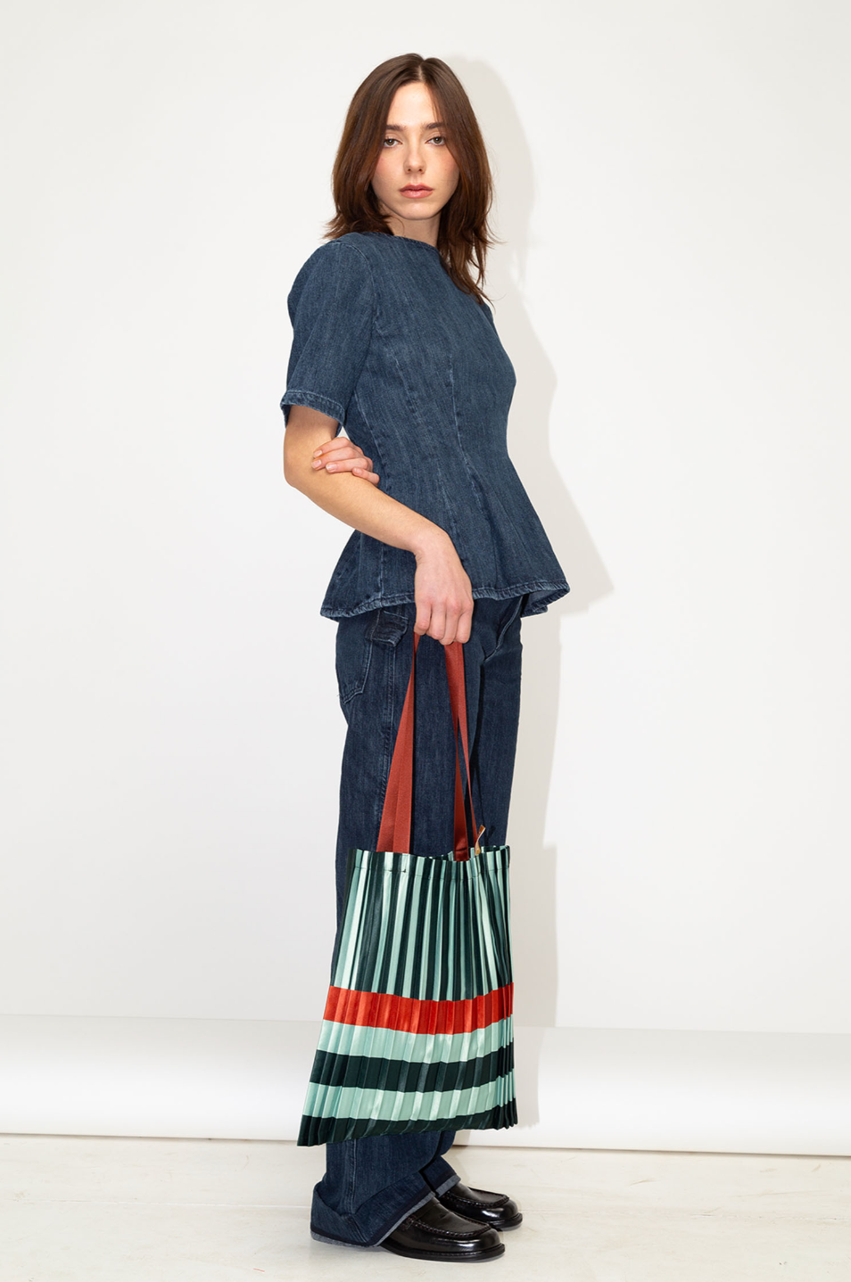 Bolso tote Smeralda plisado de Multitudes en verde y naranja. Diseño elegante y sostenible fabricado en Italia con satén reciclado.