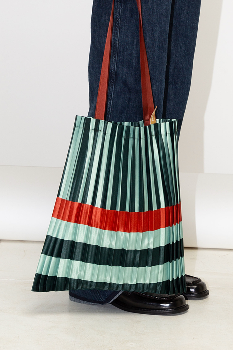 Bolso tote Smeralda plisado de Multitudes en verde y naranja. Diseño elegante y sostenible fabricado en Italia con satén reciclado.