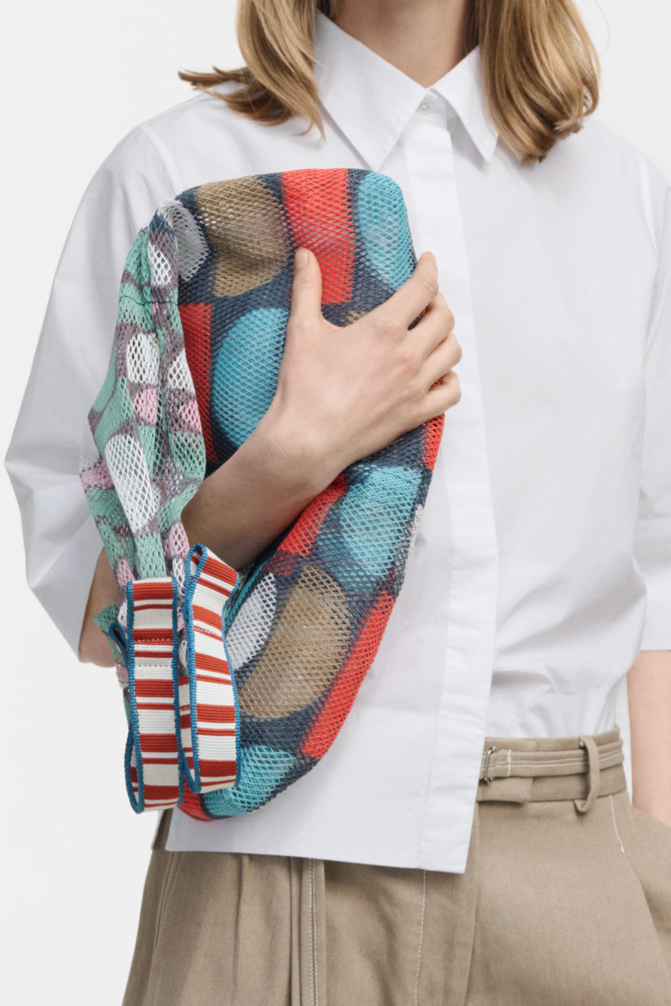 Close-up of small Udaipur Ginger multicolor patchwork mesh tote bag with red, teal and white pattern and striped cotton handles