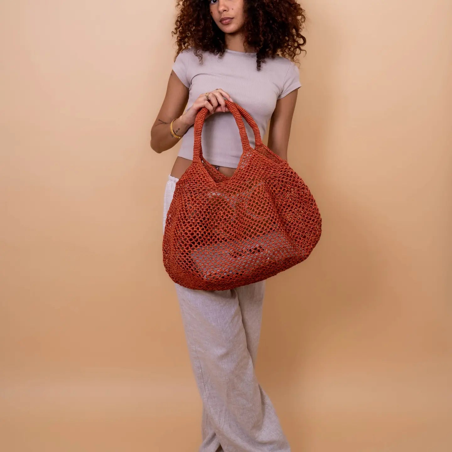 Dale un toque original y veraniego a tu estilo con esta cesta calada hecha a mano en rafia natural. Su diseño ligero, fresco y colorido es perfecto para acompañarte en días de playa, escapadas urbanas o looks relajados de verano.

Elaborada con rafia natural y algodón, esta pieza combina tradición artesanal con un diseño contemporáneo. La rafia, fibra vegetal extraída de hojas de palma, conserva su textura natural y aporta un acabado único a cada cesta.

