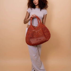 Dale un toque original y veraniego a tu estilo con esta cesta calada hecha a mano en rafia natural. Su diseño ligero, fresco y colorido es perfecto para acompañarte en días de playa, escapadas urbanas o looks relajados de verano.

Elaborada con rafia natural y algodón, esta pieza combina tradición artesanal con un diseño contemporáneo. La rafia, fibra vegetal extraída de hojas de palma, conserva su textura natural y aporta un acabado único a cada cesta.

