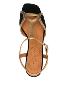 Sandalia Chie Mihara LIPE de tacón medio en ante negro con detalles dorados, tira al tobillo y cierre con hebilla lateral. Diseño elegante y cómodo, hecho en España