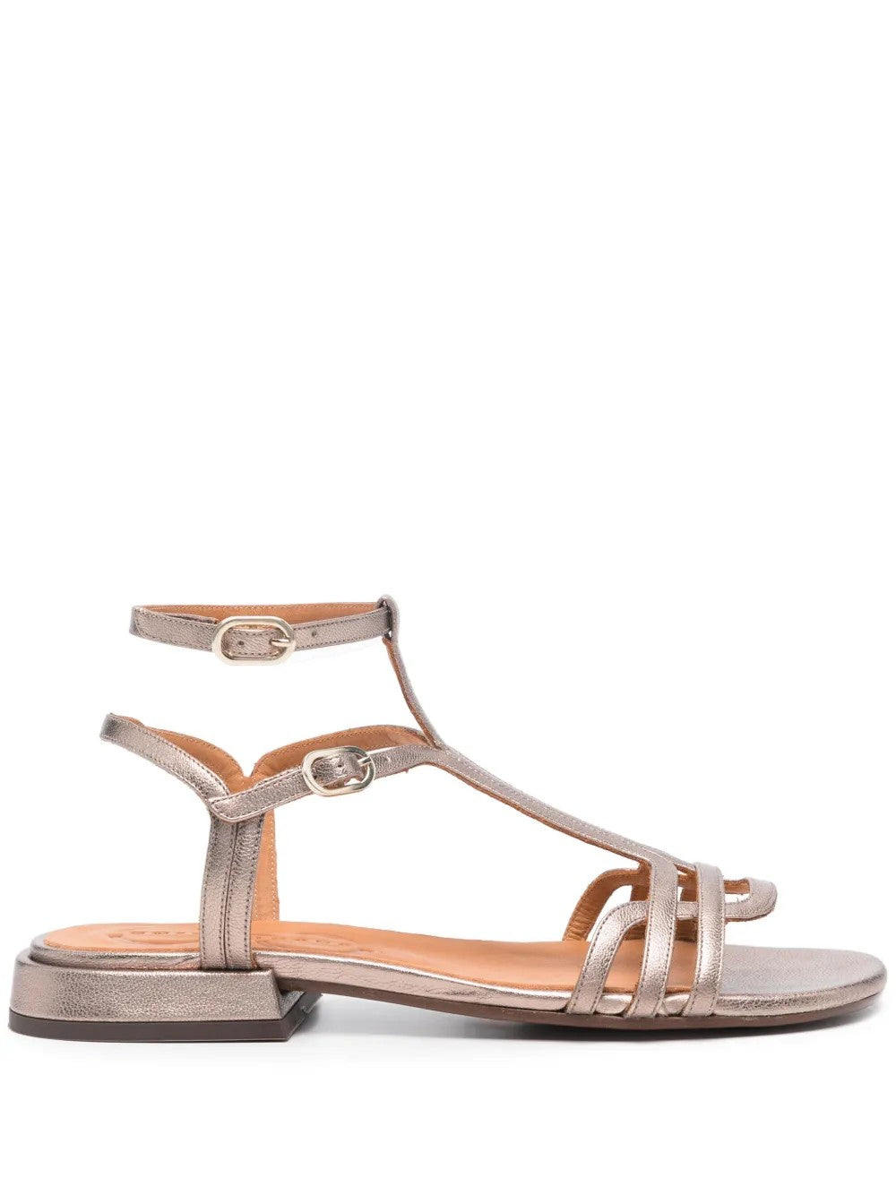 Sandalia plana Chie Mihara TYAL en piel plateada con cierre doble al tobillo y hebilla lateral. Con puntera abierta y tacón de 3 cm, es el calzado perfecto para un look cómodo y elegante. Fabricada en España, ideal para cualquier ocasión.