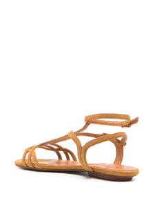 Sandalia plana Chie Mihara YAEL en ante coñac, con cierre doble al tobillo y hebilla lateral. Diseño elegante con puntera abierta y suela plana, ideal para el día a día.