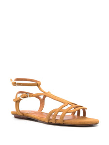 Sandalia plana Chie Mihara YAEL en ante coñac, con cierre doble al tobillo y hebilla lateral. Diseño elegante con puntera abierta y suela plana, ideal para el día a día.