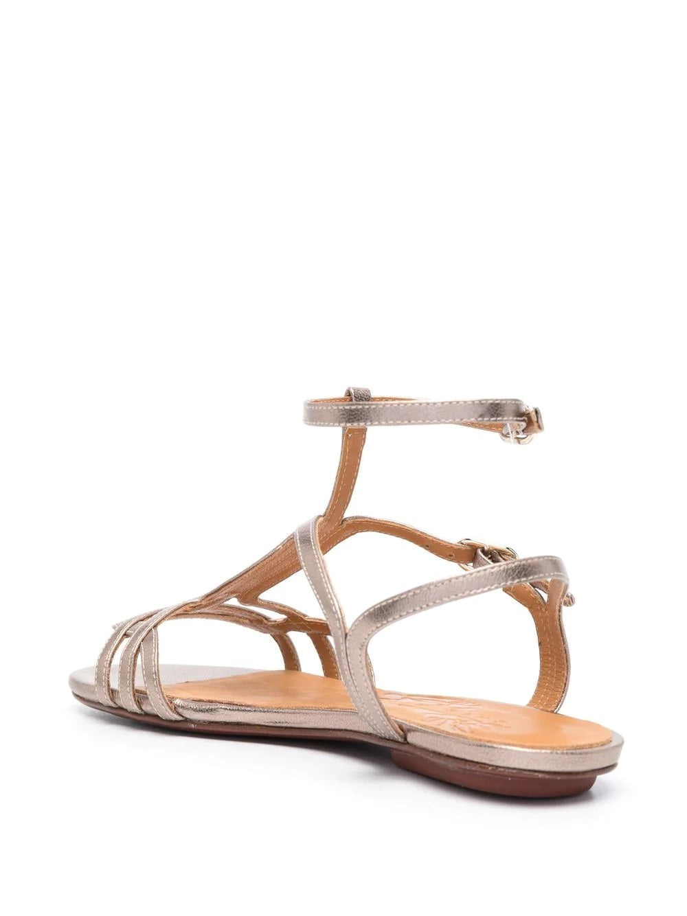 Sandalia plana Chie Mihara YAEL en piel plateada con cierre doble al tobillo, hebilla lateral y puntera abierta. Suela plana de cuero y goma, diseño cómodo y elegante.