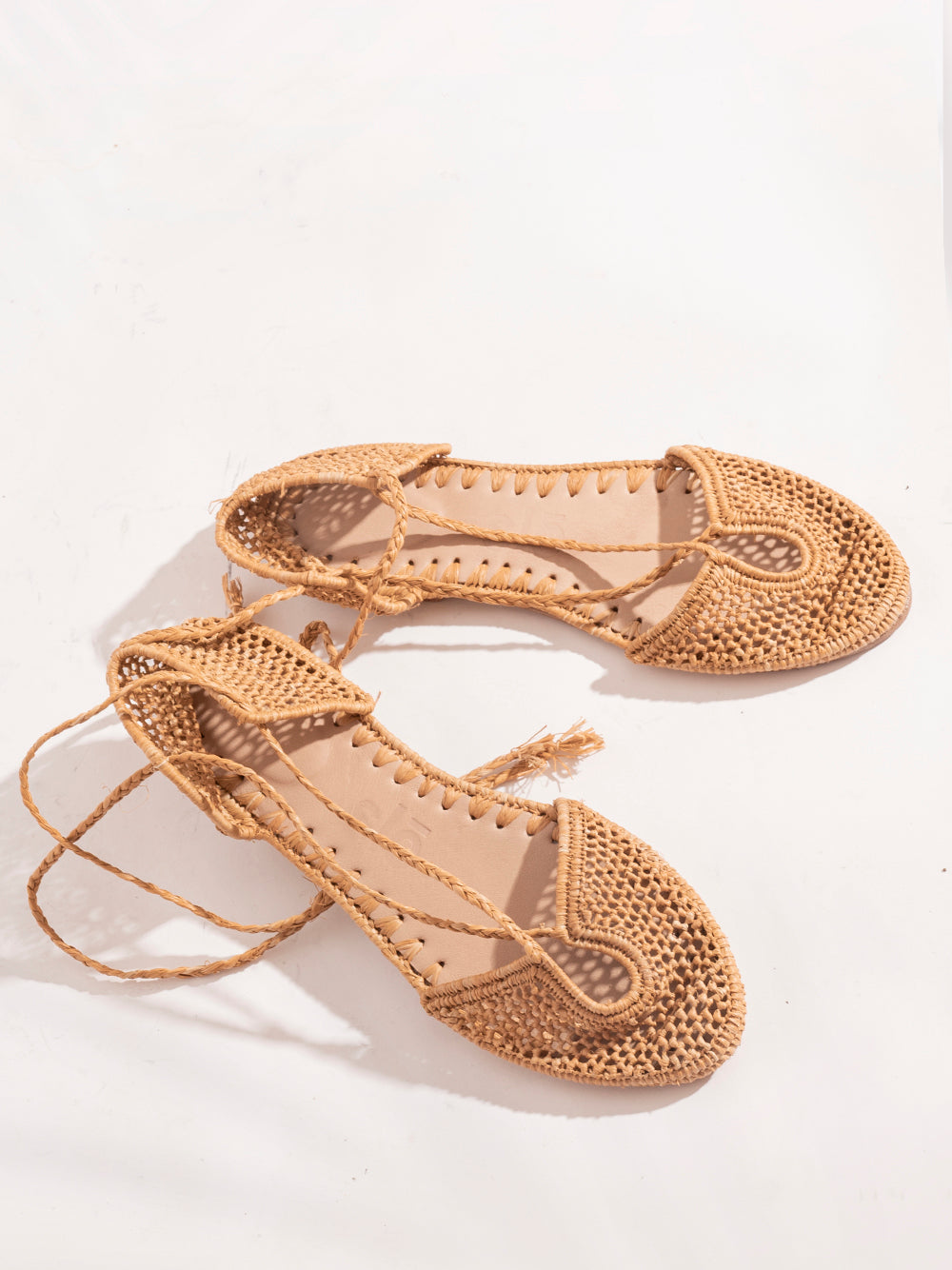 Sustainable raffia flats in natural sand shade with roman straps and leather sole