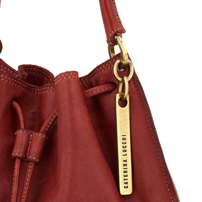 Adelaide Red Cardinal bag by Caterina Lucchi, close-up of gold brand tag and drawstring closure
