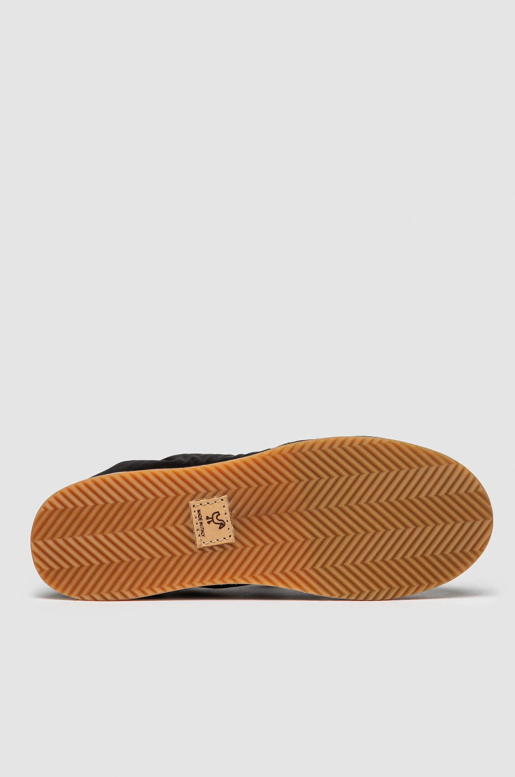 Elia Maurizi Carmen sneaker outsole view showing natural gum rubber with herringbone pattern and brand label, biodegradable sole