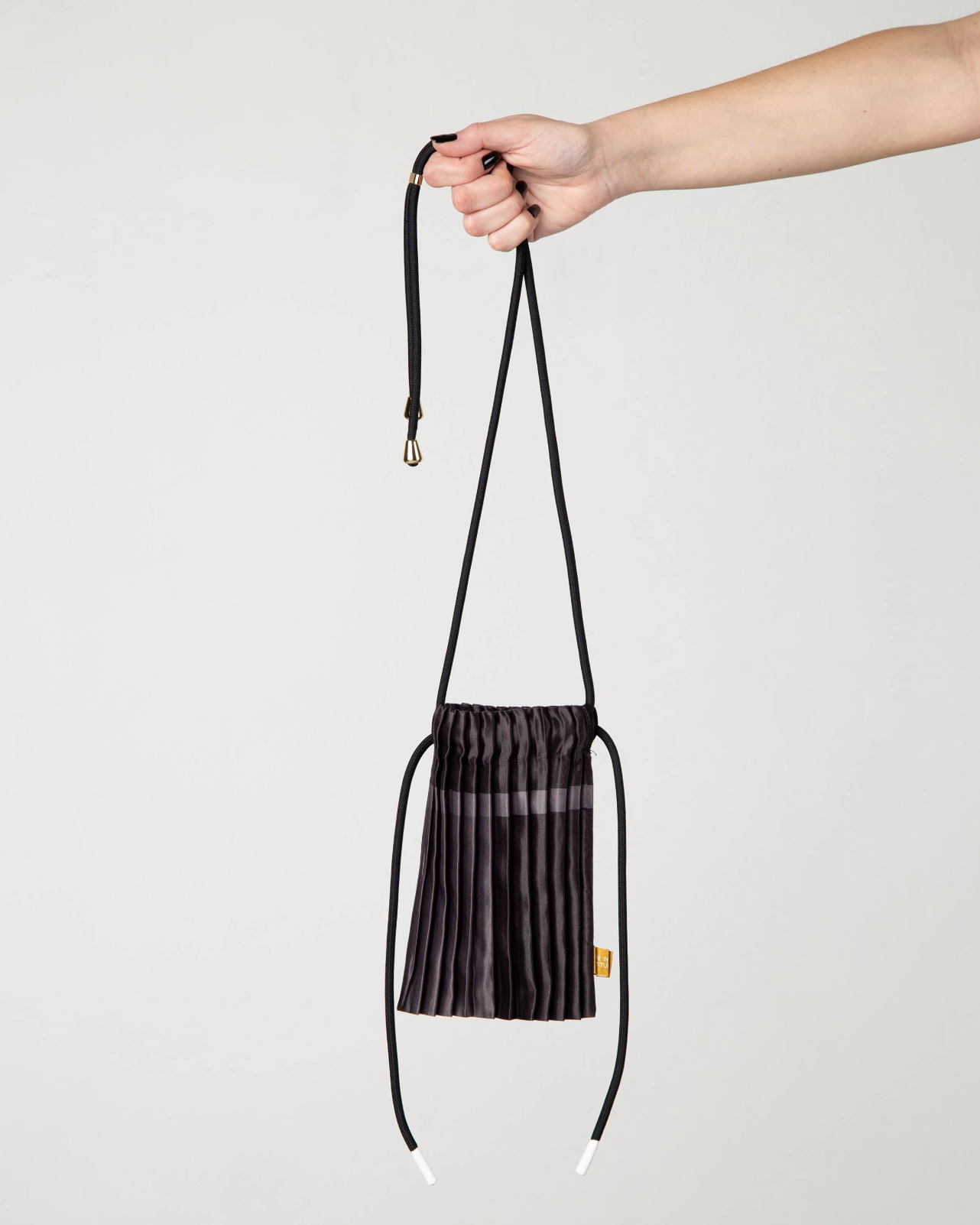 Multitudes pleated mini bag black worn crossbody front view
