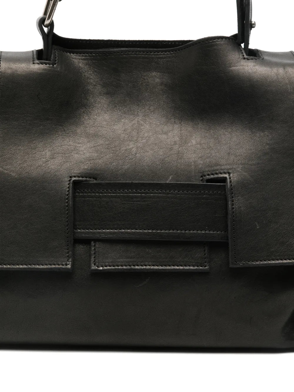 Black structured leather handbag with geometric flap and adjustable strap, handcrafted in Italy.