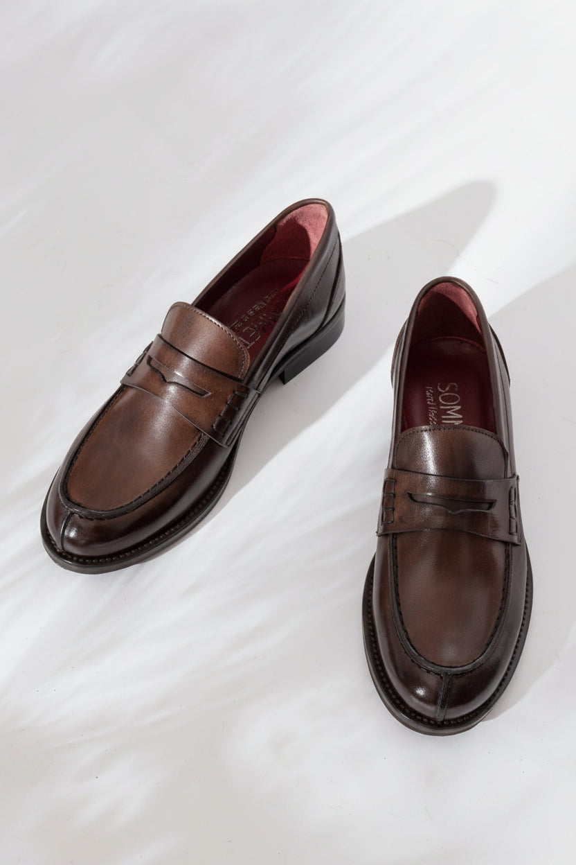 SOMMET penny loafer in Old Brown leather with flexible sole and low heel. Handmade in Italy with vegetable tanning. Classic, timeless style built to last.
