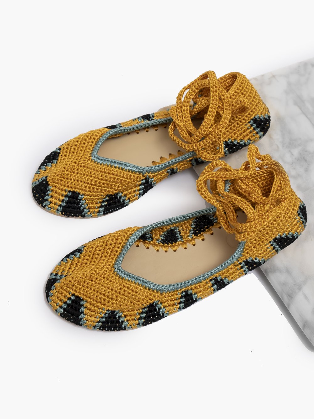 Bailarinas planas de punto crochet tejidas a mano en color amarillo, negro y turquesa, con cierre de tiras romanas. Están realizadas en algodón y rayón teñidos a mano con tintes naturales, esta combinación de materiales hace que sean un poco elásticas lo que les da un ajuste perfecto y gran comodidad. Perfectas para resaltar cualquier look.    Exterior: 60% Rayón, 40% Algodón Interior: Cuero 100% Suela: Goma 100%  Color: Daylily_yellow