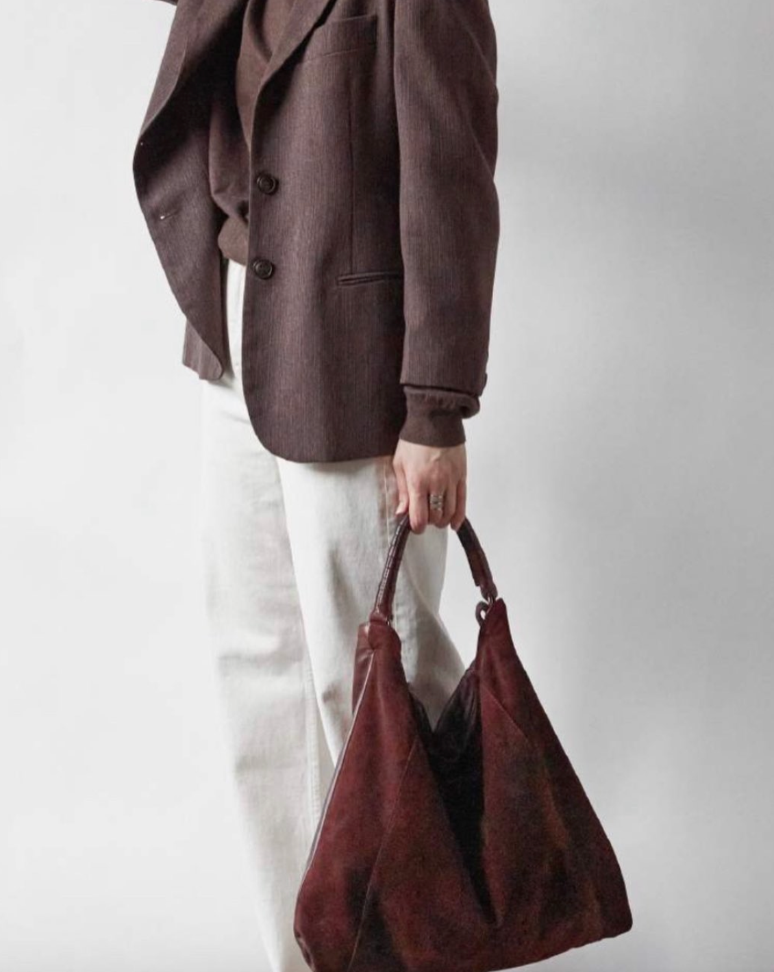 Bolso en ante vino con asa de cuero trenzado.  Cierre de cremallera oculta y con un bolsillo interno con cremallera. Forro de algodón Opción de una segunda asa para poderlo llevar de bandolera con hebilla ajustable a una longitud máxima de 120 cm.  Alto: 45 cm (con asa) Ancho: 45 cm Profundidad: 11 cm Hecho en Italia  Modelo_RH-H709V97135-VINO-SUEDE