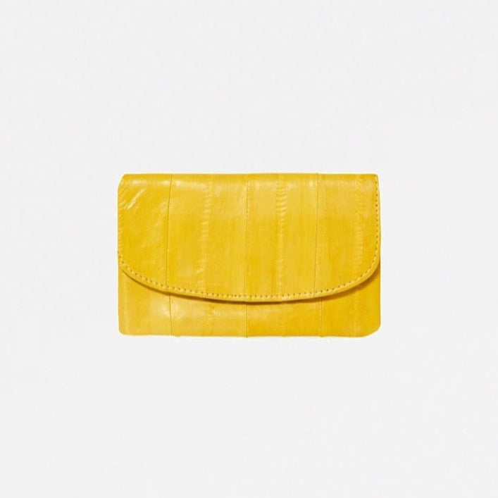 Monedero amarillo con solapa y cierre a presión, en piel de anguila suave, compartimentos para tarjetas de crédito.   Medidas: Ancho: 11 cm, altura: 7 cm.  Forro interior 100 % algodón.  Material exterior: 100% piel de anguila.